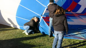 I'm holding down the neck of the balloon so air fills it instead of escaping below it.